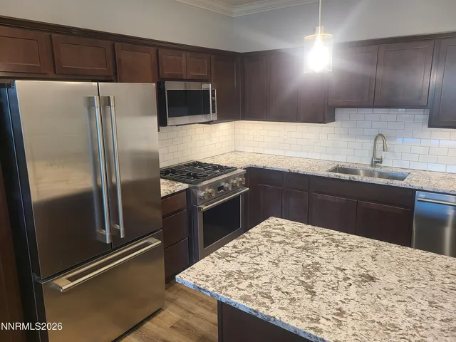 a kitchen with stainless steel appliances granite countertop a sink stove and refrigerator