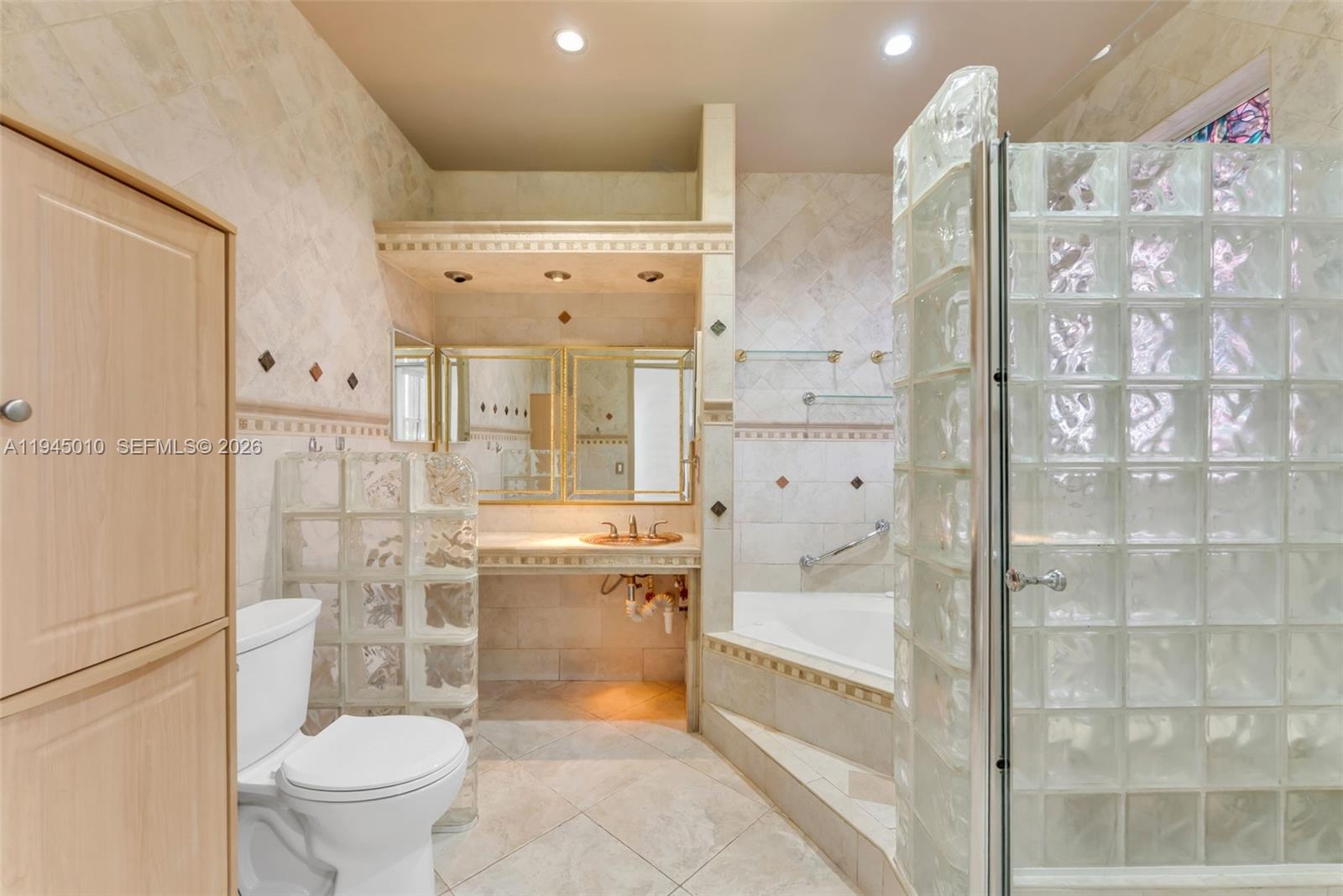 13296 Southwest 54th Court Miramar, FL 33027 - Photo 14 of 34 a bathroom with a granite countertop toilet sink and shower