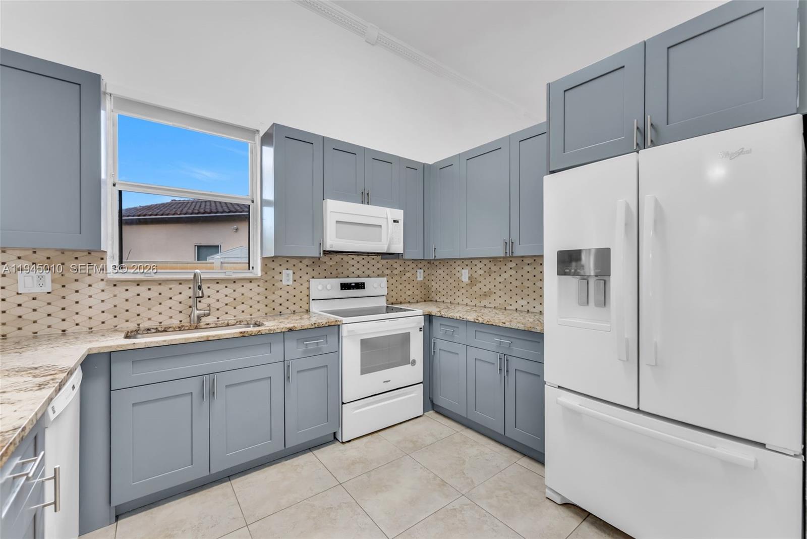 13296 Southwest 54th Court Miramar, FL 33027 - Photo 29 of 34 a kitchen with white cabinets and white appliances