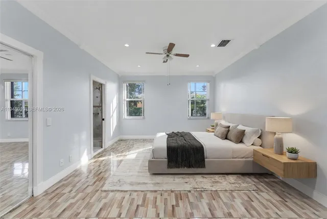 a bedroom with a large bed and wooden floor