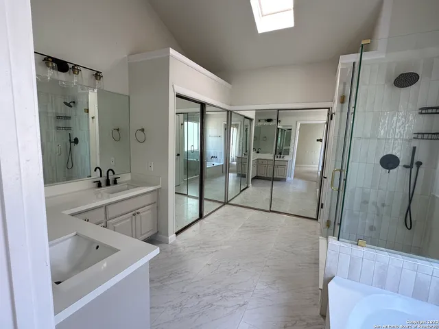 a bathroom with a double vanity sink mirror and shower