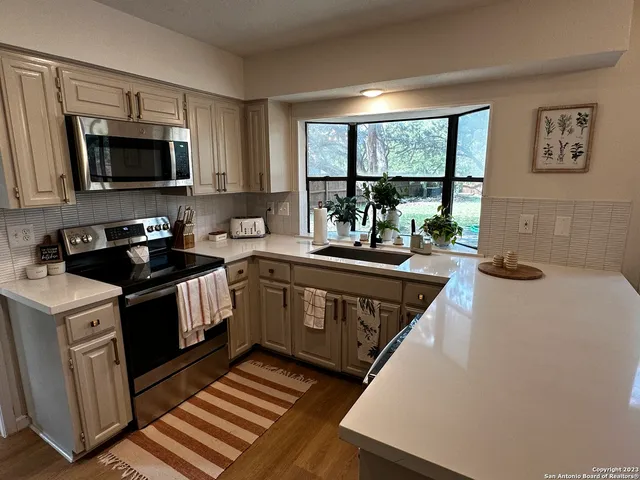 an empty room with fireplace wooden floor and windows