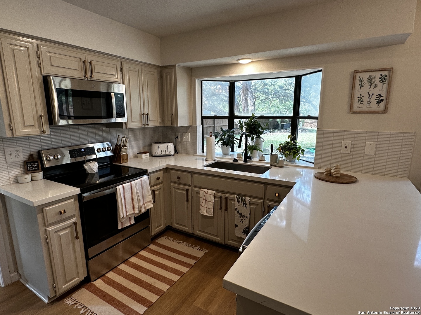 1722 Encino Spring San Antonio, TX 78259 - Photo 31 of 55 a kitchen with a stove a sink and a microwave