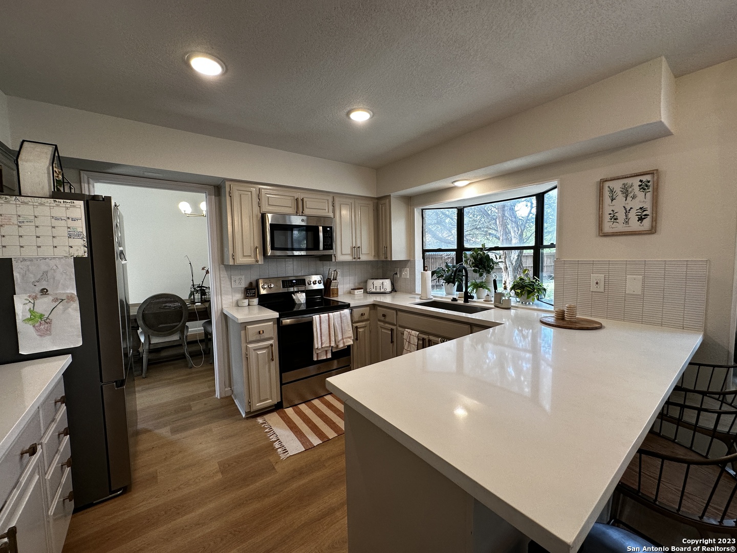 1722 Encino Spring San Antonio, TX 78259 - Photo 32 of 55 a kitchen with sink a refrigerator and chairs