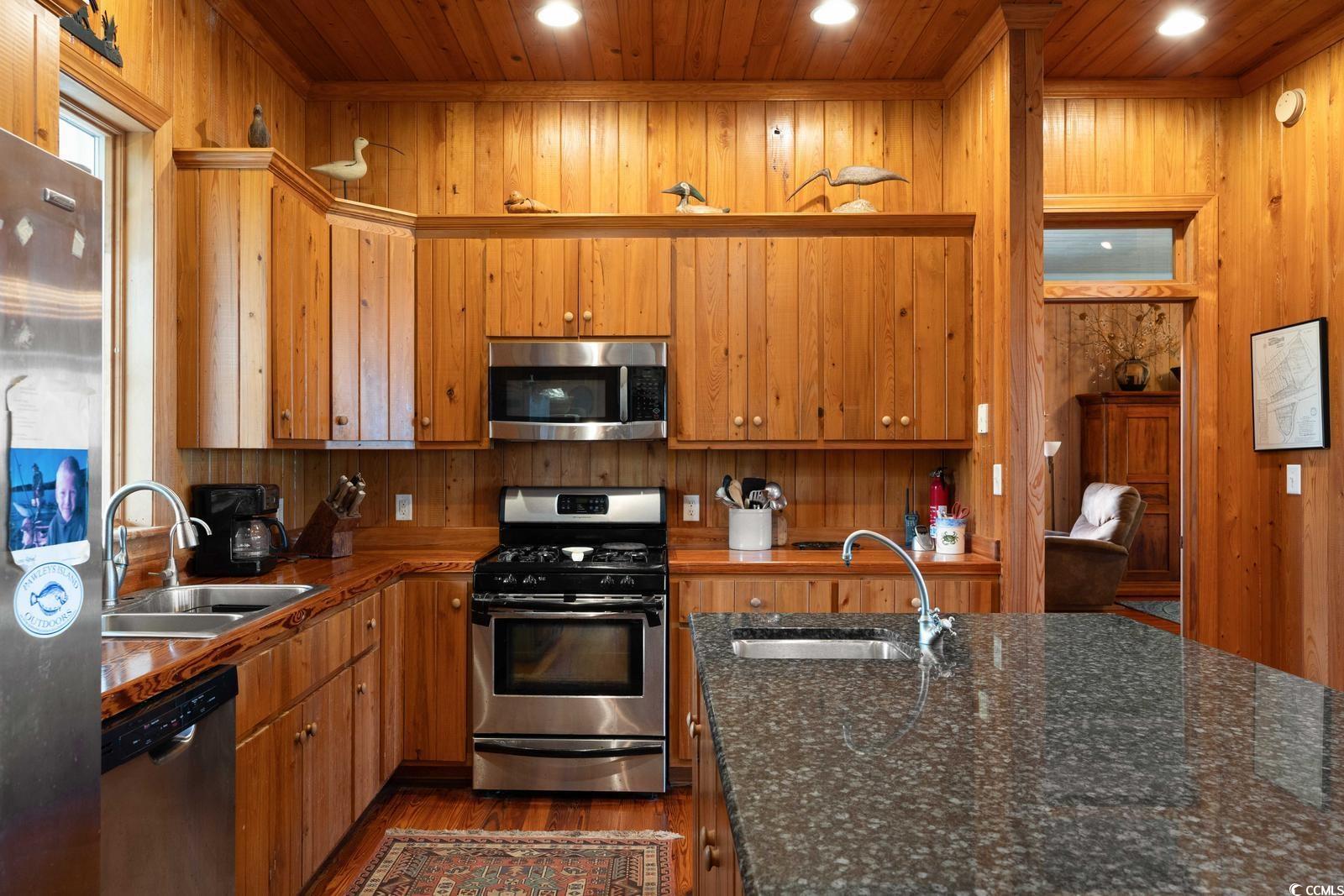 315 Lofton Court McClellanville, SC 29458 - Photo 22 of 40 Kitchen featuring stainless steel appliances, wooden walls, dark wood-type flooring, wood ceiling, and recessed lighting