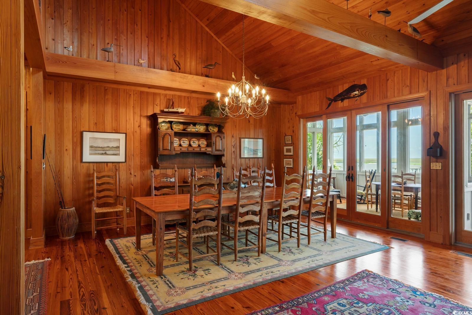 315 Lofton Court McClellanville, SC 29458 - Photo 24 of 40 Dining area with wood walls, a chandelier, wood-type flooring, and wood ceiling
