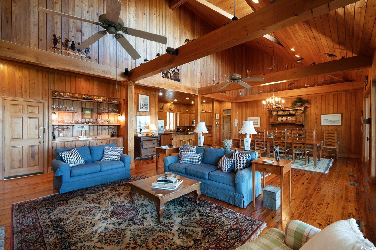 315 Lofton Court McClellanville, SC 29458 - Photo 27 of 40 Living area featuring a ceiling fan, wood walls, high vaulted ceiling, a chandelier, and beamed ceiling