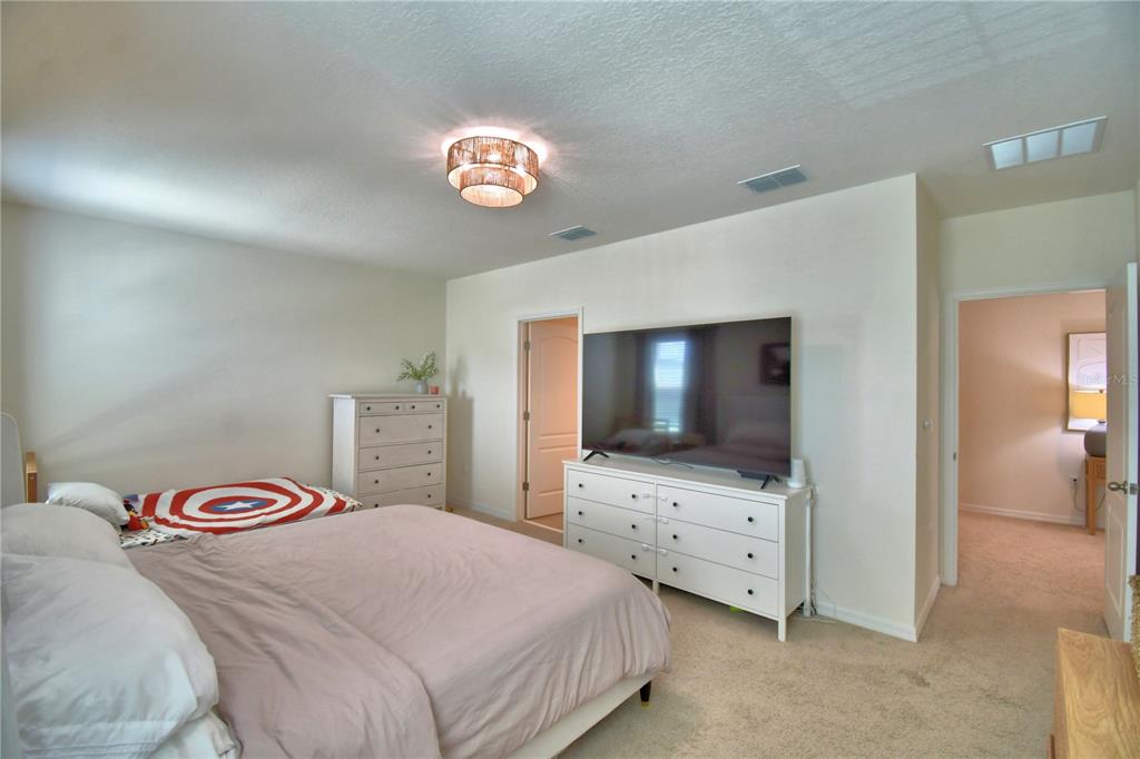 2839 Moulin Road Davenport, FL 33837 - Photo 32 of 75 a bedroom with a bed and a flat screen tv