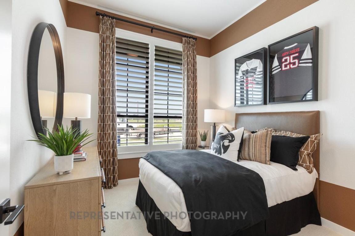 205 Leaning Rock Ridge Austin, TX 78737 - Photo 40 of 40 a bedroom with a large bed and a potted plant next to a window