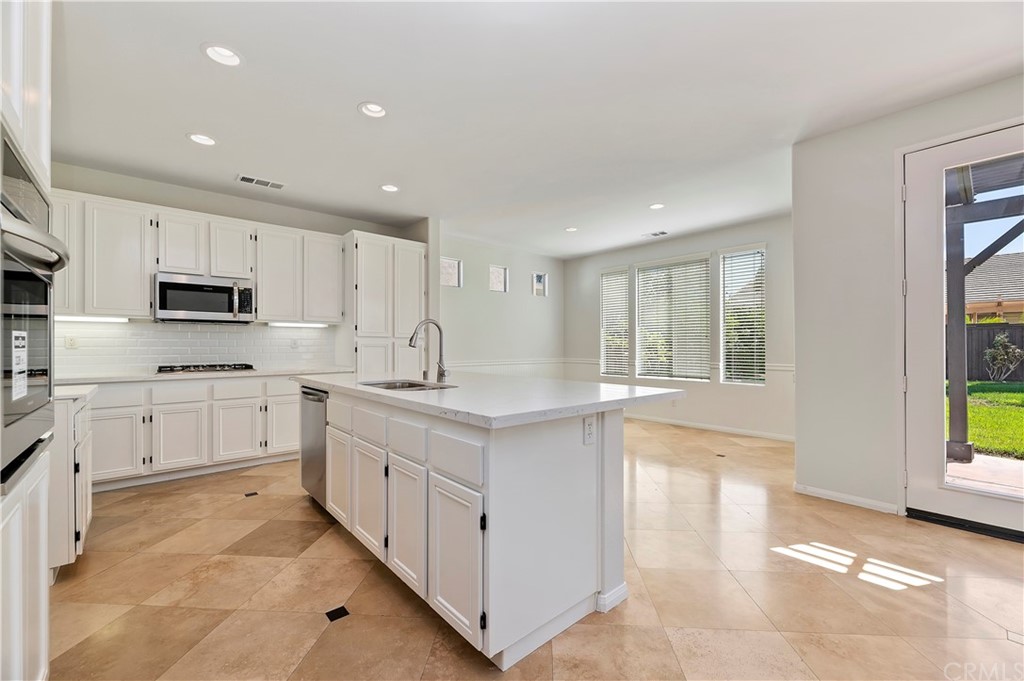 13527 Jasper Loop Eastvale, CA 92880 - Photo 12 of 37 a kitchen with white cabinets and white appliances