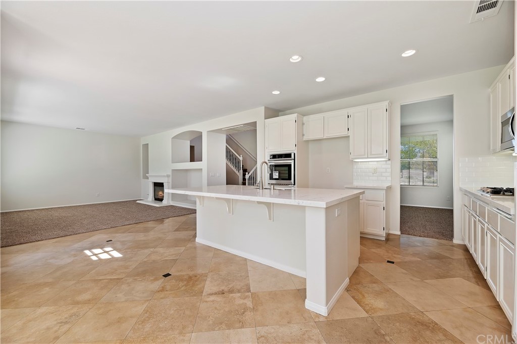13527 Jasper Loop Eastvale, CA 92880 - Photo 14 of 37 a view of kitchen with center island and stainless steel appliances