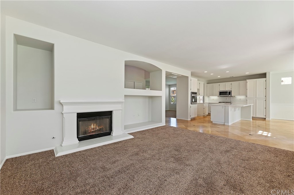 13527 Jasper Loop Eastvale, CA 92880 - Photo 18 of 37 a view of empty room with a kitchen and fireplace