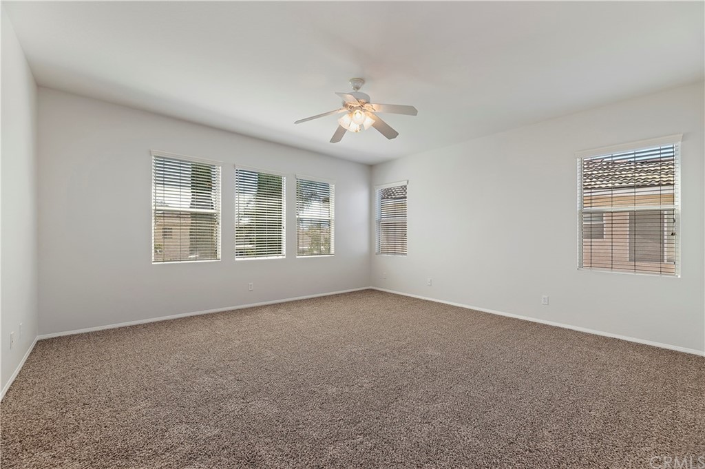 13527 Jasper Loop Eastvale, CA 92880 - Photo 23 of 37 an empty room with windows and ceiling fan