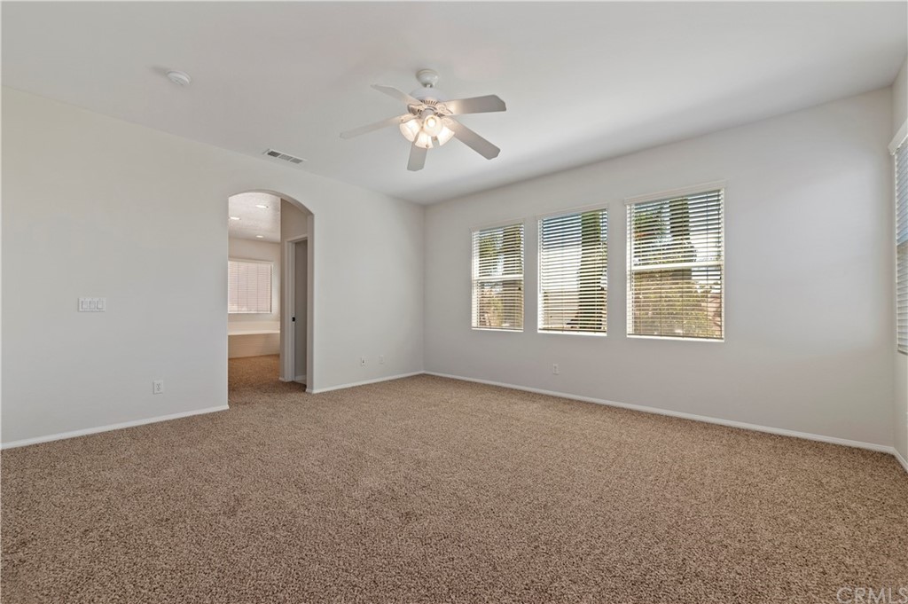13527 Jasper Loop Eastvale, CA 92880 - Photo 24 of 37 an empty room with chandelier fan and windows