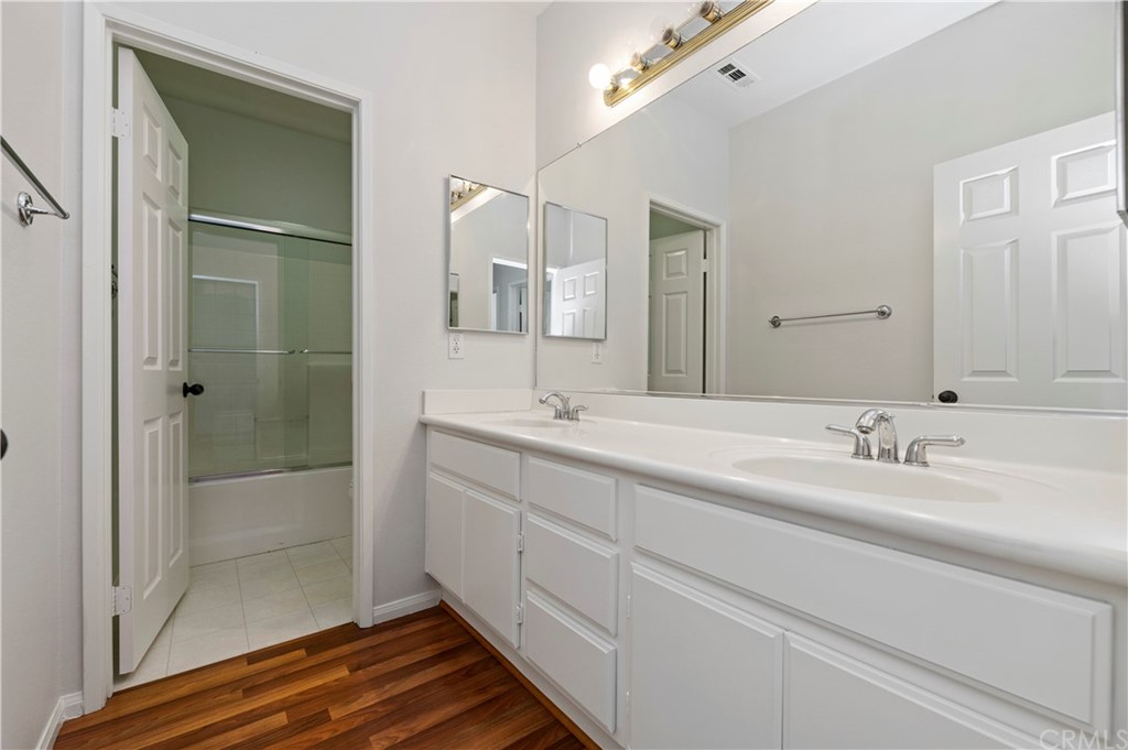 13527 Jasper Loop Eastvale, CA 92880 - Photo 30 of 37 a bathroom with a double vanity sink and shower