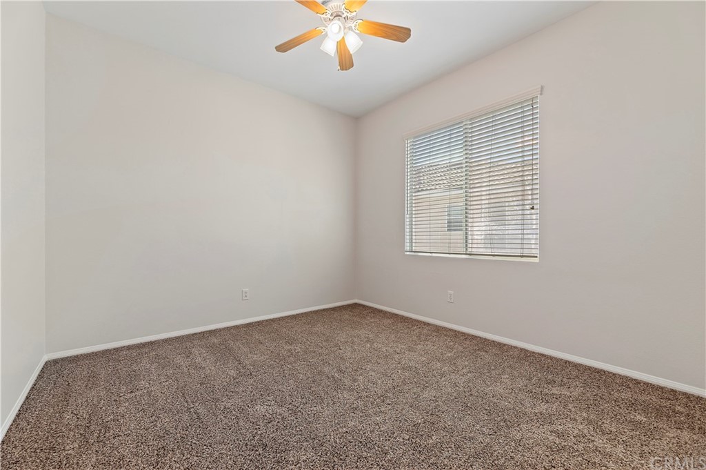 13527 Jasper Loop Eastvale, CA 92880 - Photo 31 of 37 an empty room with chandelier fan and windows