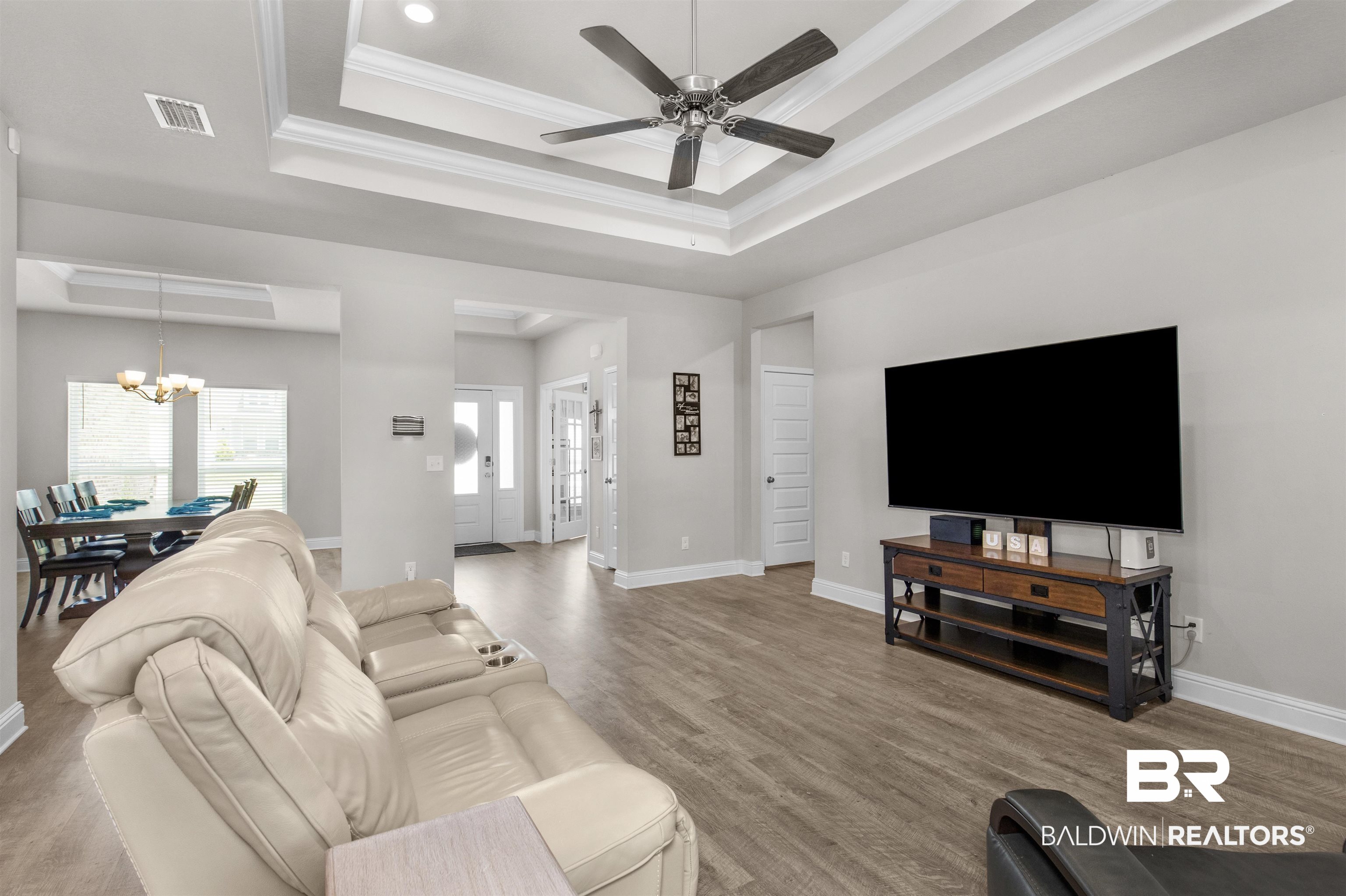 2345 Laurel Street Semmes, AL 36575 - Photo 6 of 31 Living area featuring a tray ceiling, a chandelier, a ceiling fan, ornamental molding, and wood finished floors