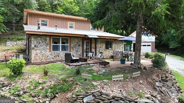 a view of a house with backyard sitting area and garden