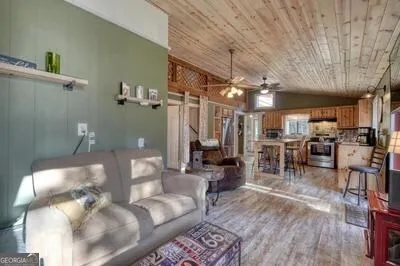 a kitchen with stainless steel appliances granite countertop a stove a refrigerator a sink dishwasher and white cabinets with wooden floor