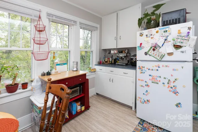 a kitchen with stainless steel appliances a stove a refrigerator a sink a dining table and chairs