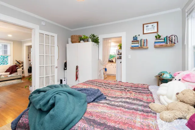 a bedroom with a bed and wooden floor