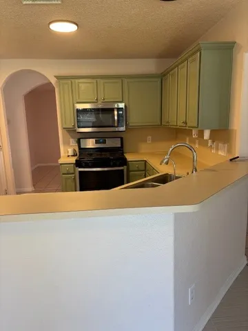 a kitchen with stainless steel appliances a sink and a refrigerator