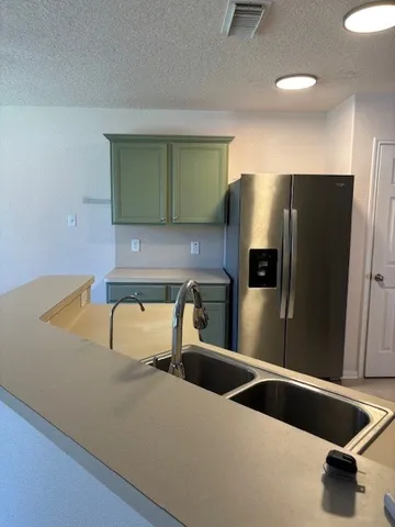 a kitchen with stainless steel appliances a sink and a refrigerator
