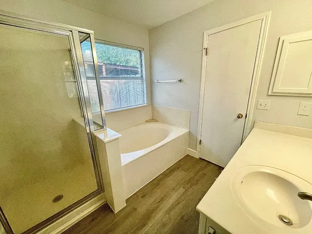 a bathroom with a tub a sink and a shower