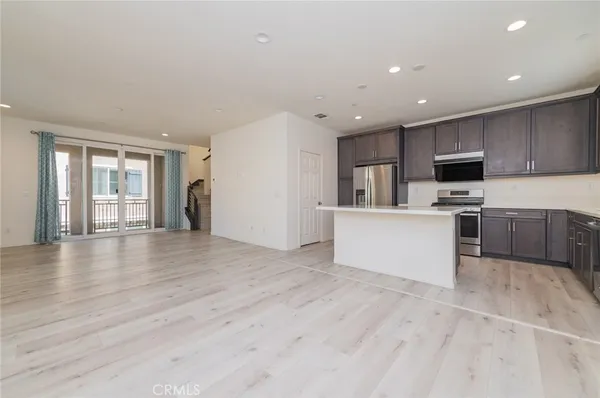 a large kitchen with a refrigerator and a stove top oven