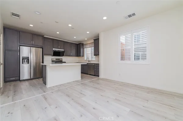 a kitchen with kitchen island a sink stainless steel appliances and cabinets