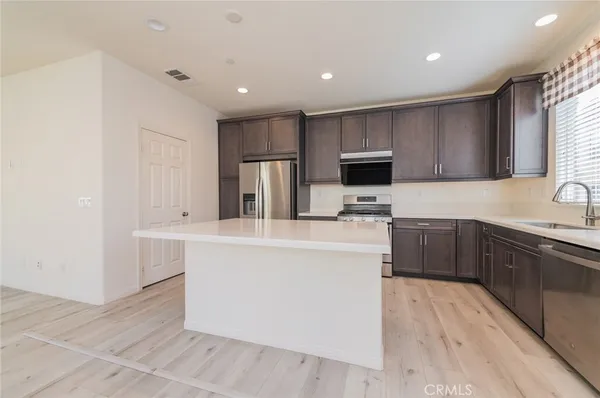 a kitchen with kitchen island a sink appliances and cabinets