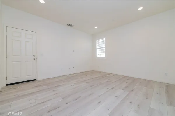 an empty room with wooden floor and stairs