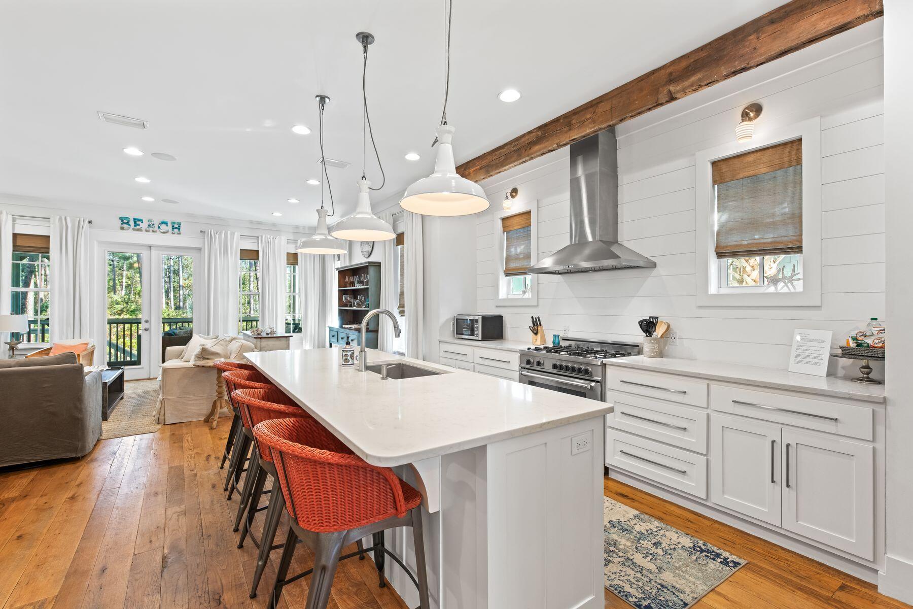 75 Lifeguard Loop West Seacrest, FL 32461 - Photo 11 of 37 a kitchen with stainless steel appliances granite countertop a stove a sink dishwasher a oven a dining table and chairs with wooden floor