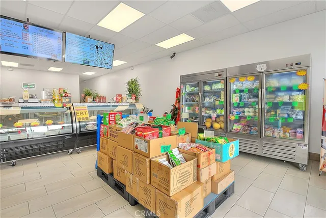 a room with stainless steel appliances lots of fruit and a table & chairs in it