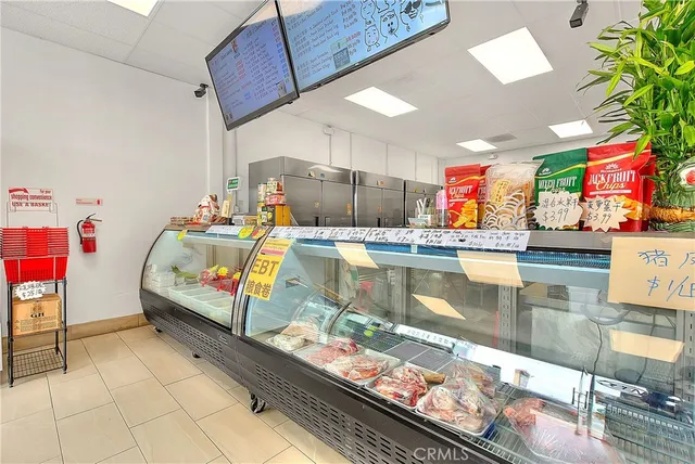 a hallway view with the couches and dining table with white walls