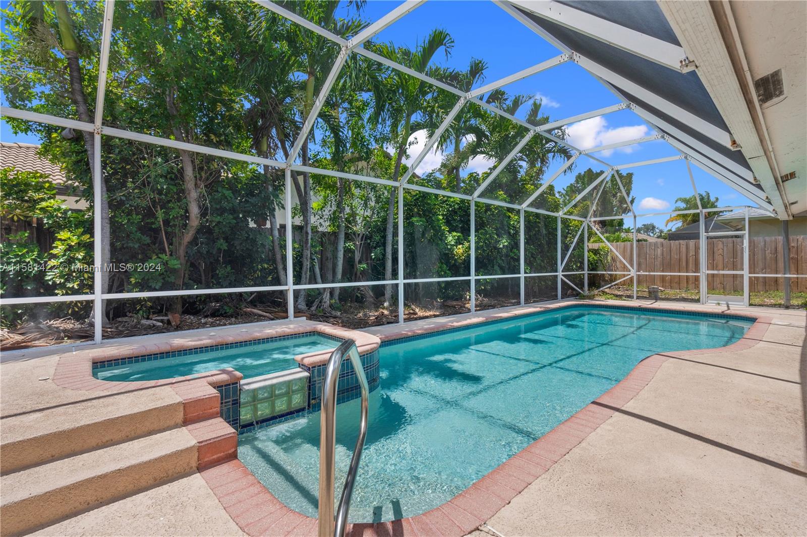 17689 Woodview Terrace Boca Raton, FL 33487 - Photo 13 of 15 a view of a backyard with floor to ceiling windows and wooden fence