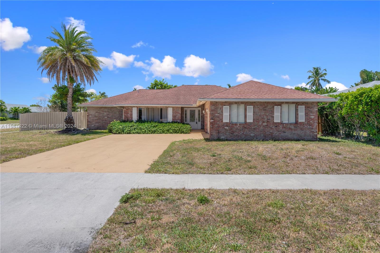 17689 Woodview Terrace Boca Raton, FL 33487 - Photo 2 of 15 a front view of a house with a yard and palm tree