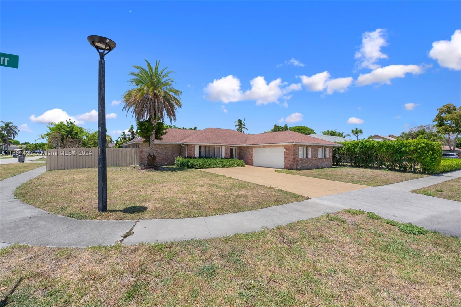 17689 Woodview Terrace Boca Raton, FL 33487 - Photo 3 of 15 a front view of a house with a yard and trees