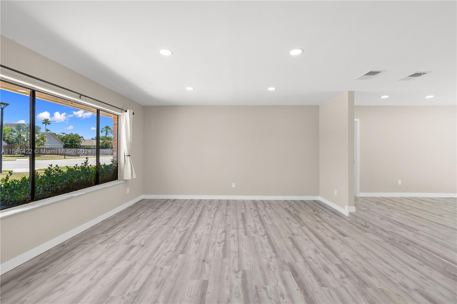17689 Woodview Terrace Boca Raton, FL 33487 - Photo 5 of 15 an empty room with wooden floor and windows