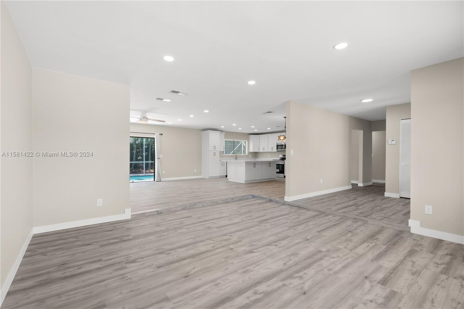17689 Woodview Terrace Boca Raton, FL 33487 - Photo 6 of 15 a view of empty room with wooden floor and kitchen