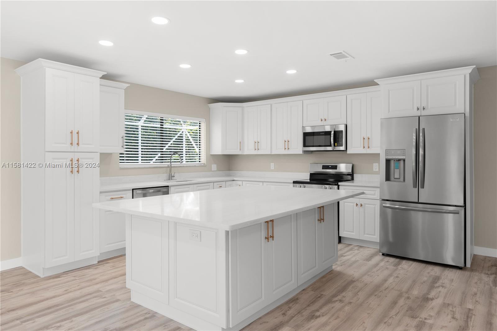 17689 Woodview Terrace Boca Raton, FL 33487 - Photo 7 of 15 a kitchen with stainless steel appliances granite countertop a refrigerator a stove a sink and white cabinets with wooden floor