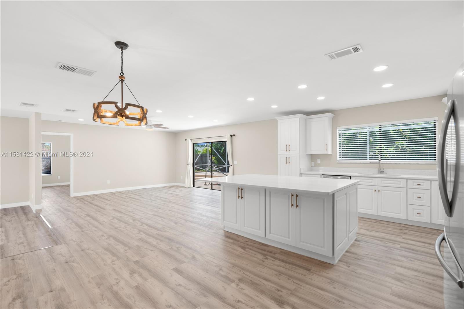 17689 Woodview Terrace Boca Raton, FL 33487 - Photo 8 of 15 a large kitchen with granite countertop a stove a sink a center island and wooden floor