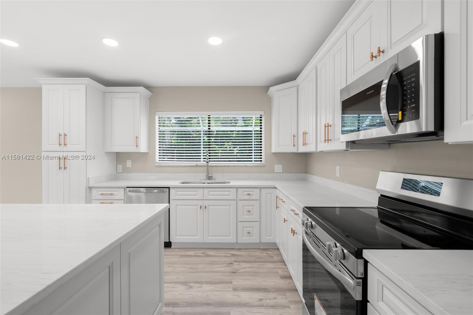 17689 Woodview Terrace Boca Raton, FL 33487 - Photo 9 of 15 a kitchen with stainless steel appliances granite countertop a stove a sink and a microwave