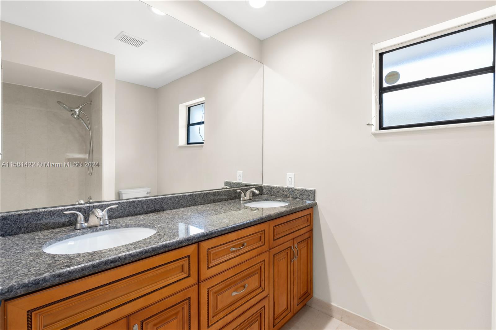 17689 Woodview Terrace Boca Raton, FL 33487 - Photo 10 of 15 a bathroom with a granite countertop sink and a mirror