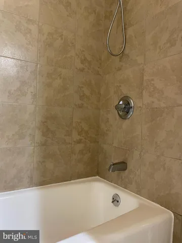 a bathroom with a bath tub with a shower