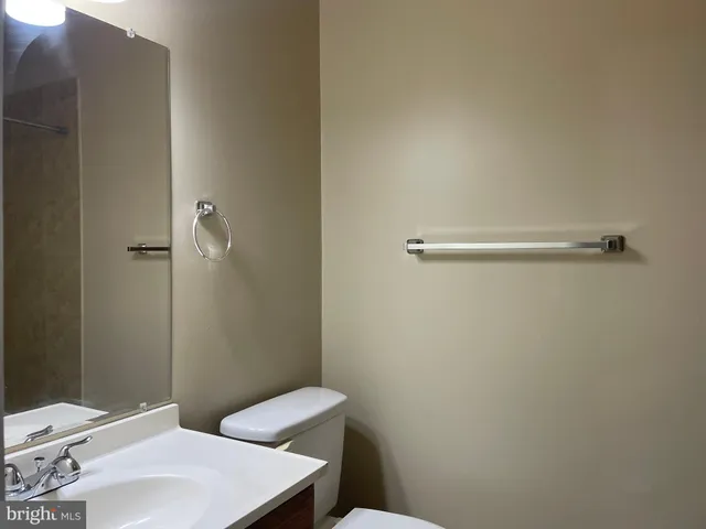 a bathroom with a sink a toilet and a mirror