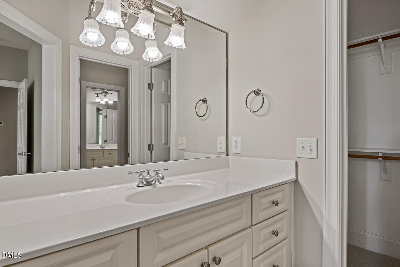 4004 Frontenac Court Apex, NC 27539 - Photo 45 of 61 a bathroom with a sink a light fixture and a mirror
