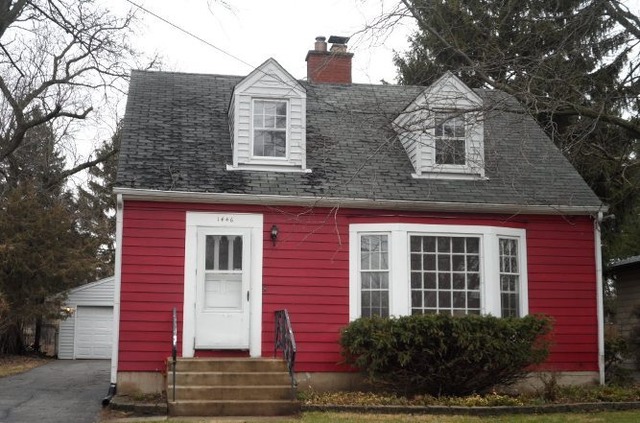 a view of a brick house with large windows and a yard