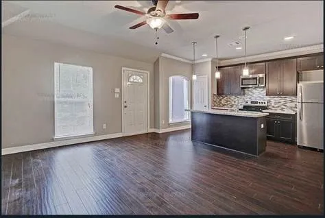 a kitchen with stainless steel appliances granite countertop a sink cabinets and wooden floor