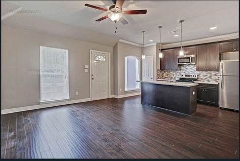 4204 Stassen Street, Unit B Houston, TX 77051 - Photo 2 of 11 a kitchen with stainless steel appliances granite countertop a sink cabinets and wooden floor